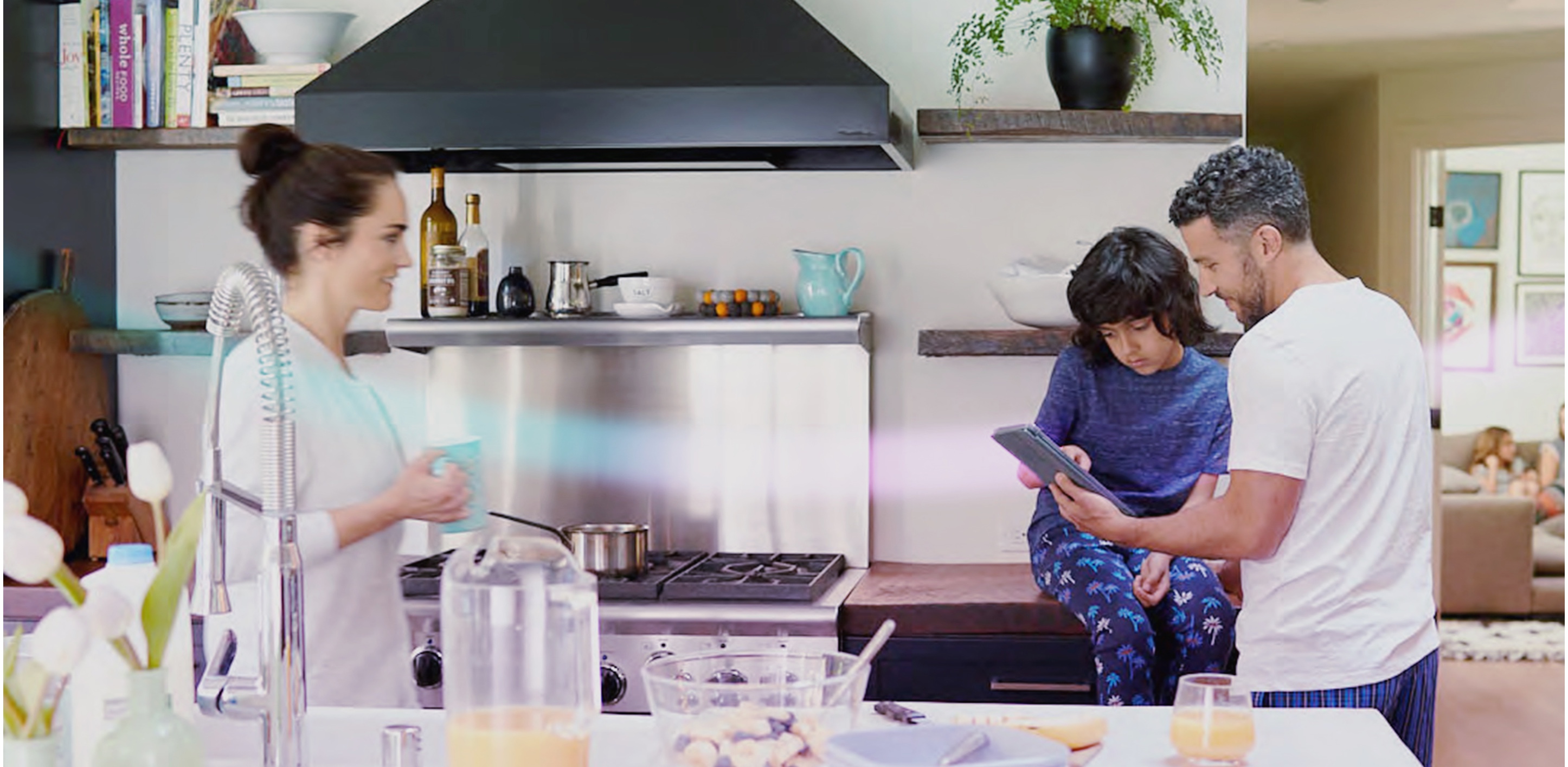 Parents in Kitchen using Tablet with Daughter 